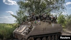 Украинские военные на бронетранспортере M113 недалеко от  Бахмута, 9 июня 2023 года.
(Фото Reuters/Вячеслав Ратынский)